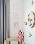 pokój dziewczynki z plakatami w motywie stokrotek na ścianie nad łóżeczkiem